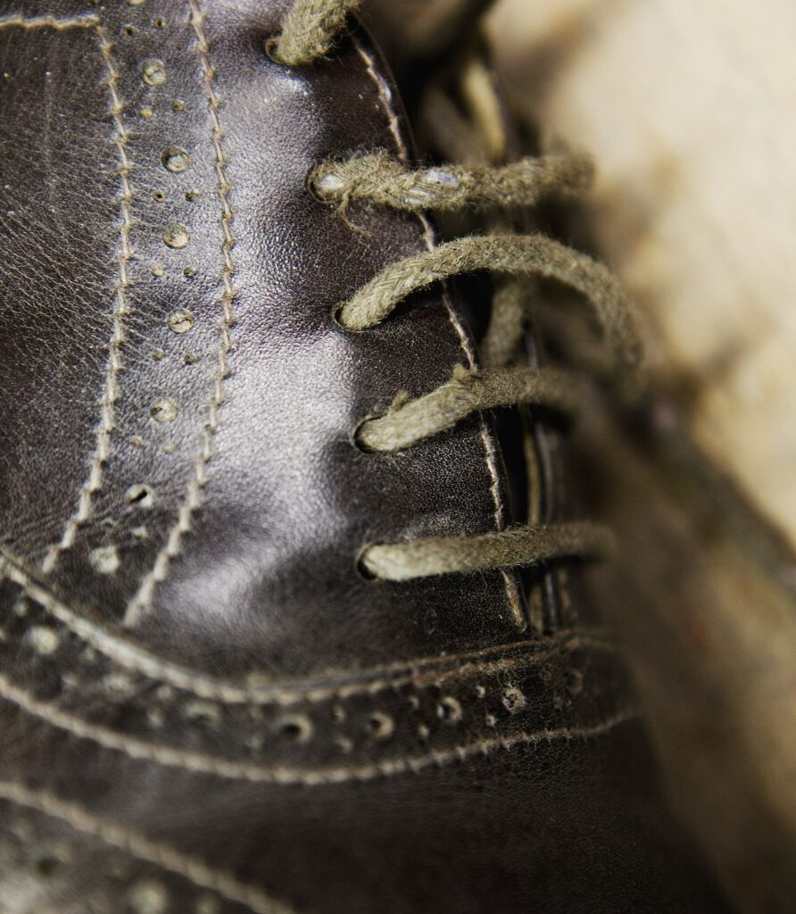 Close up of leather brogue and shoelaces in shoe makers workshop